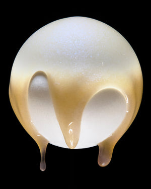 A translucent, frosted glass orb with a warm golden-yellow gradient near the bottom, featuring two heart-shaped cutouts on the front, set against a solid black background.