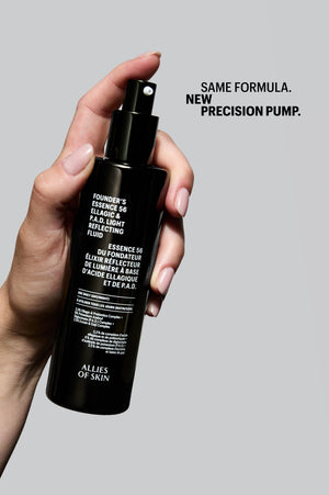 Hand holding Allies of Skin Founder's Essence 56 Ellagic & P.A.D. Light Reflecting Fluid with new precision pump, same formula