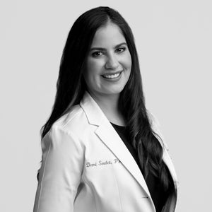 Black and white portrait of a smiling woman in a white lab coat, Allies of Skin Scientific Collective expert